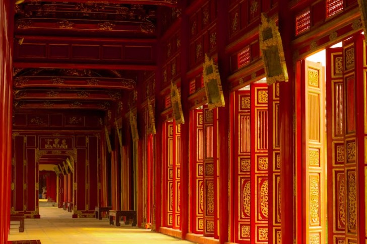 Röd korridor med utsmyckade trädörrar