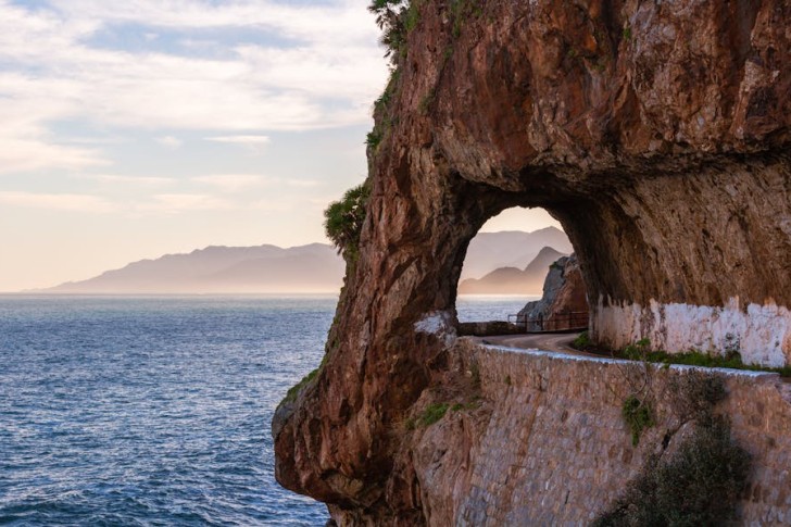 Passagem em arco no penhasco em uma estrada costeira