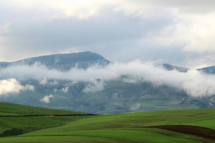 Sky over dalen sett fra de grønne åsene