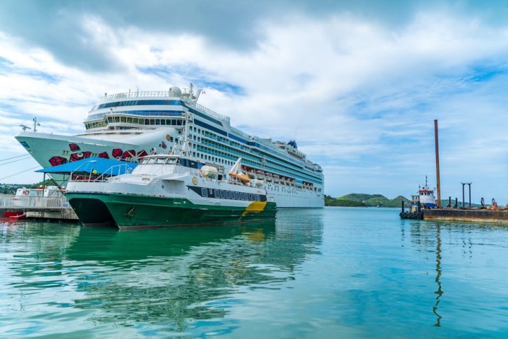 白い雲と青い空の下の海を航行する白いクルーズ船