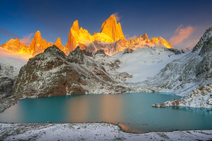パタゴニアの山々と湖の向こうに昇る太陽
