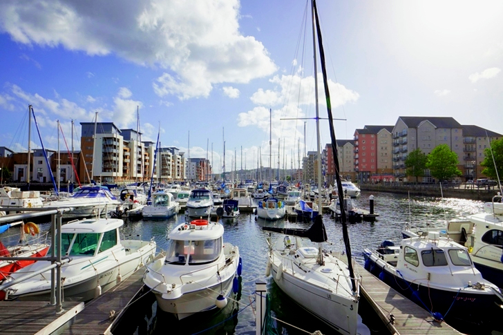 Four White Motorboats on Body of Water