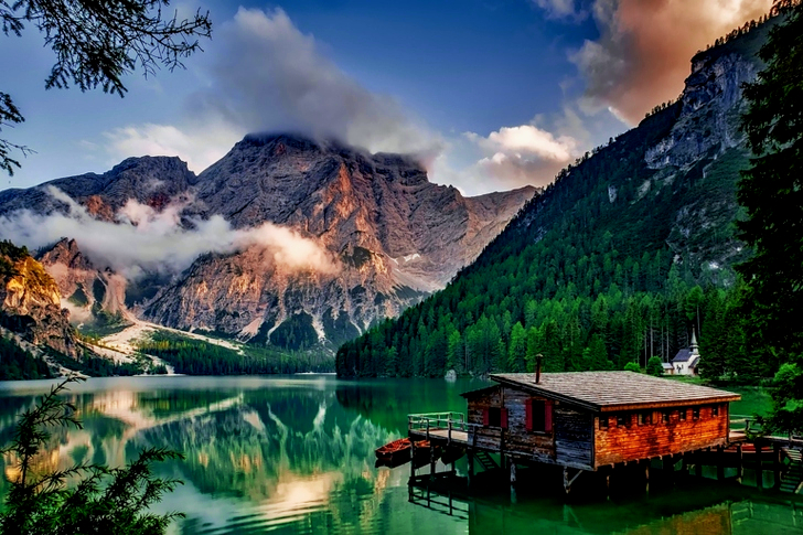 Mirror Lake Reflecting Wooden House in Middle of Lake Overlooking Mountain Ranges