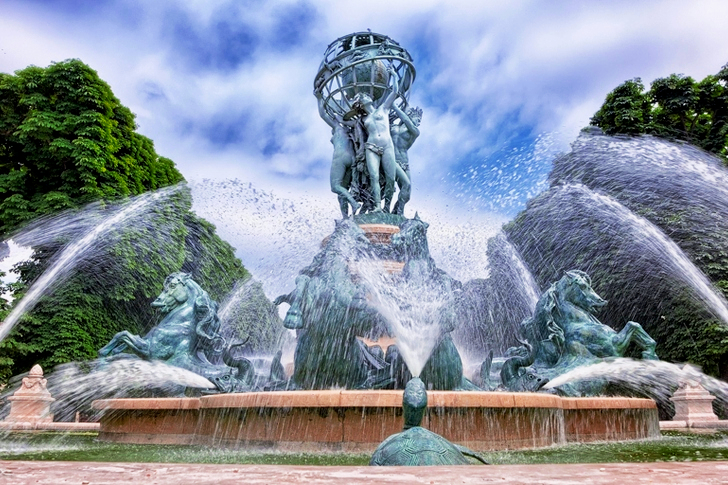 Blue Concrete Water Fountain Near Green Trees Under White Clouds