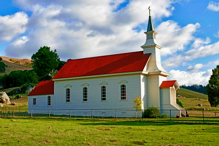 Red and White Concrete Church on Green Grass Field