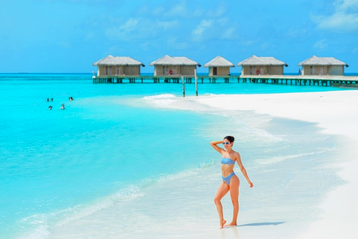 Woman Wearing Blue Bikini Standing Near the Ocean