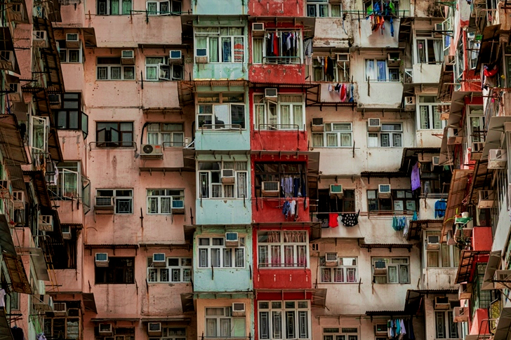 Lavvinkelbillede af en gammel lejlighedsbygning udvendig med slidt maling