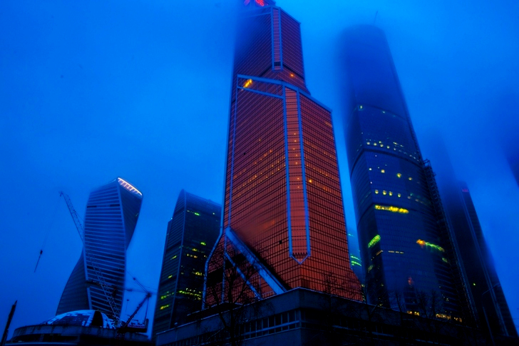 Lav vinkel på høyhus dekket med tåke