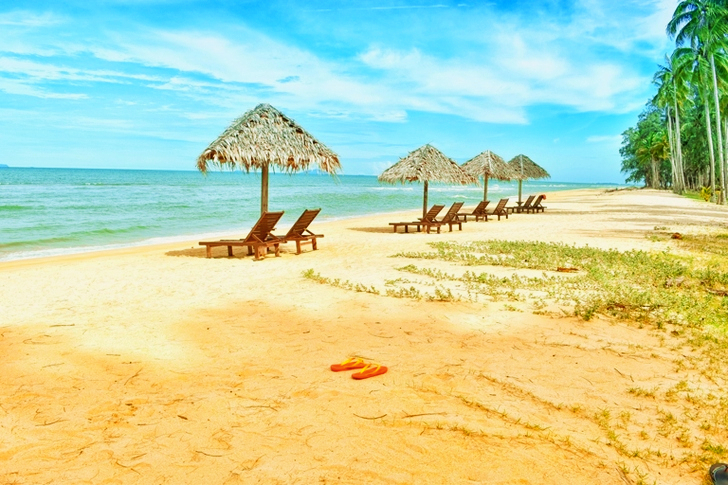 Loungers Under Parasol at Shoreline