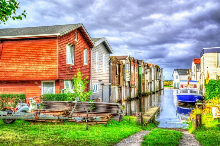Hors-bord blanc et bleu à côté des maisons