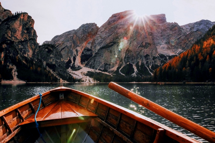 Brown Canoe in the Body of Water Near Mountain