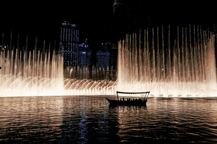 Silhouette of a Boat on a Body of Water With Fountain