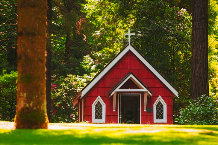 Red Chapel on Grassy Field With Trees