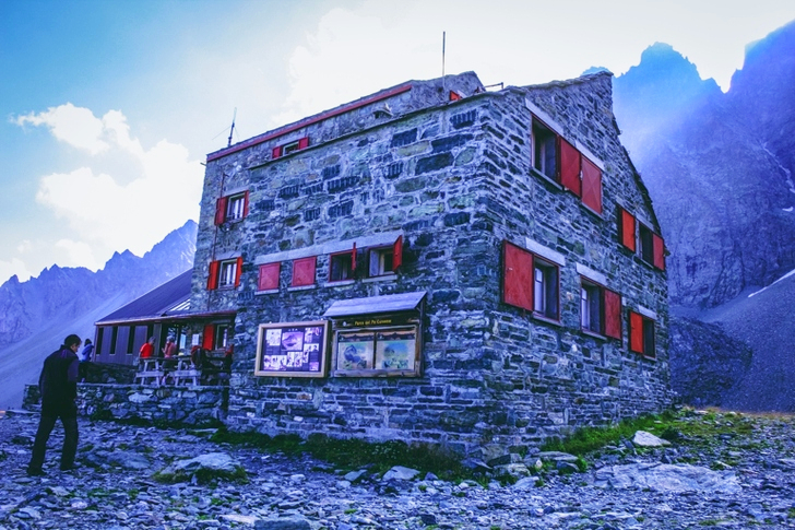 a Man in Black Sweater Standing in Front of Gray Concrete Building