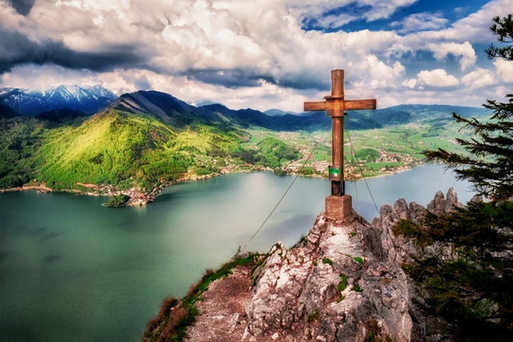 Brown Cross Near Body of Water Under White Sky