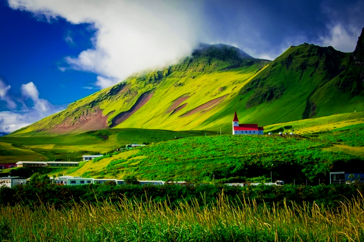 낮 동안 산 근처의 푸른 들판