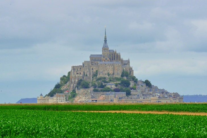 Mont Saint-michel under hvide skyer og blå himmel