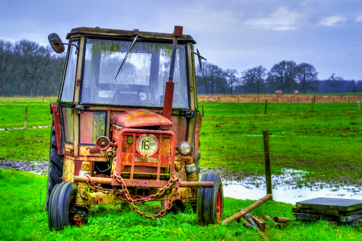 Gult gårdsutstyr på grønt gressfelt