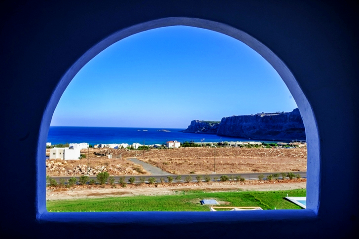 Landscape of Brown Field Near Large Body of Water