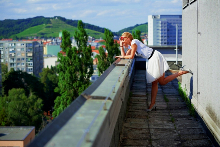 Woman Leaning on the Edge of a Building