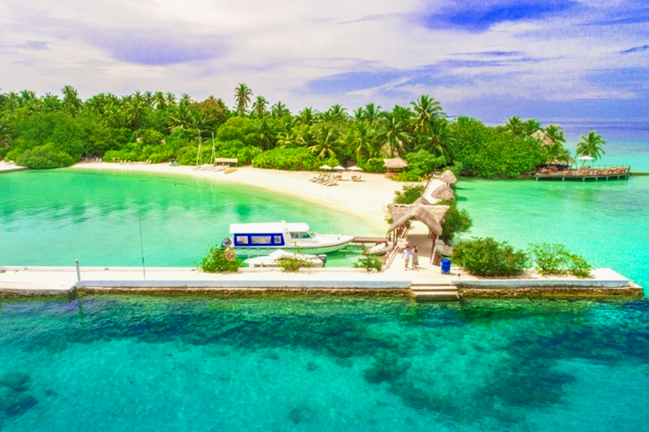 Aerial White Dock by the Ocean Surrounded With Trees Under Blue Sky and White Clouds