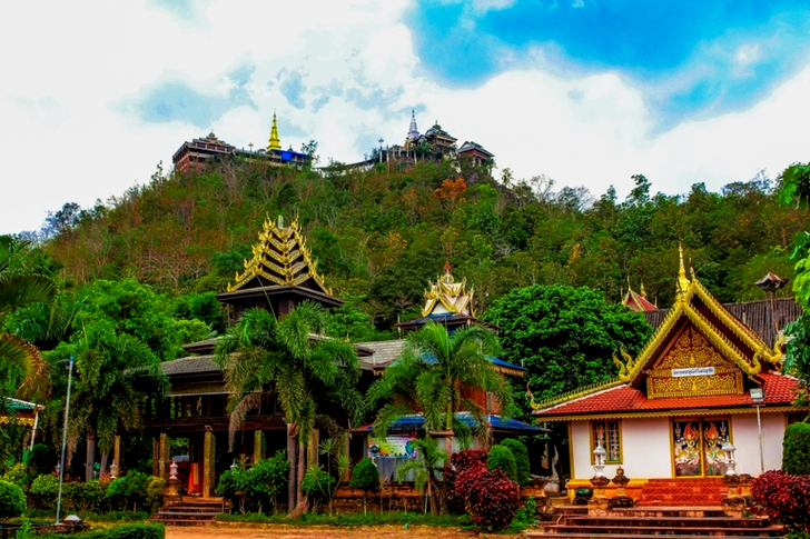 White and Orange Pagoda Near the Mountain