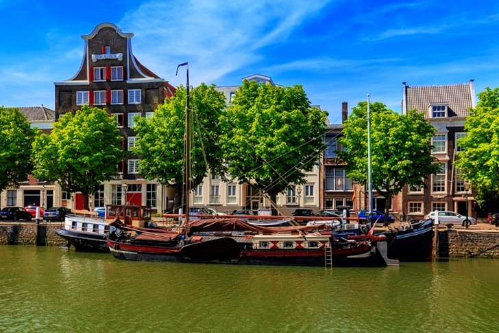 Sailboat on Dock Near Brown and Red Buildings