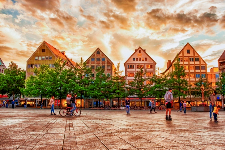 People on Concrete Pavement With Houses and Trees in Background