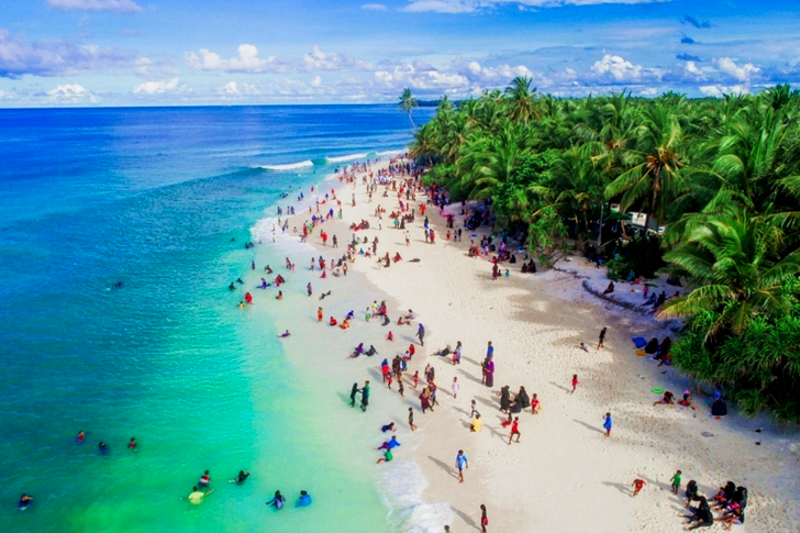 Ilmassa olevia ihmisiä merenrannalla